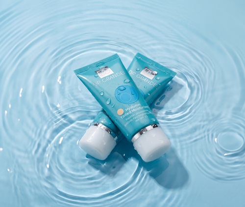 DrGrandel_Hyaluron-Tinted-Moisture Zwei Tuben Dr. Grandel Hyaluron-Tinted-Moisture Creme auf einer Wasseroberfläche